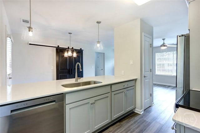 106 Oyster Catcher Ln, Savannah, GA 31410 - kitchen featuring stainless steel dishwasher, a sink, light countertops, dark wood-style floors, and pendant lighting