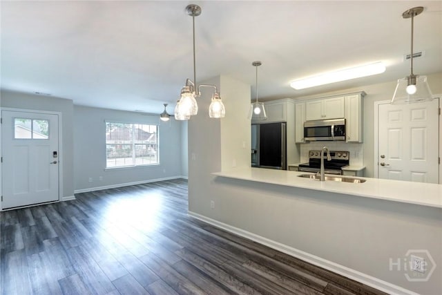 106 Oyster Catcher Ln, Savannah, GA 31410 - kitchen with appliances with stainless steel finishes, a sink, light countertops, baseboards, and dark wood-type flooring