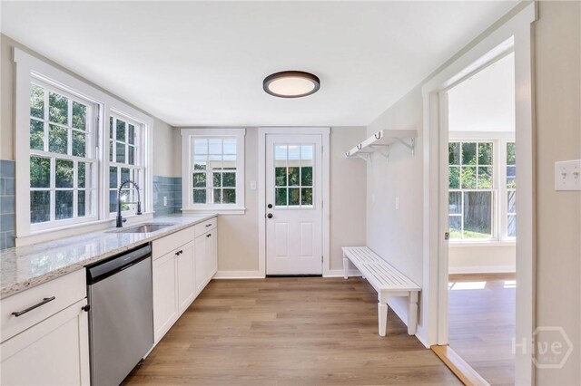 55 Saint Johns Ave, Savannah, GA 31404 - kitchen featuring dishwasher, a sink, light wood-style floors, light stone countertops, and white cabinetry