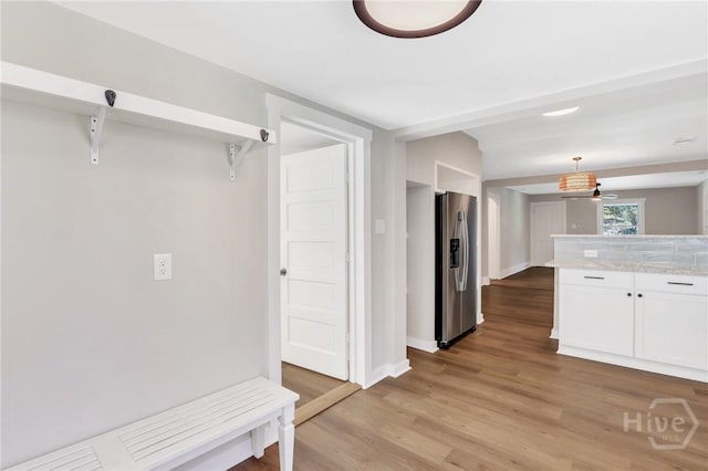 55 Saint Johns Ave, Savannah, GA 31404 - kitchen featuring stainless steel fridge, white cabinets, light wood finished floors, baseboards, and hanging light fixtures