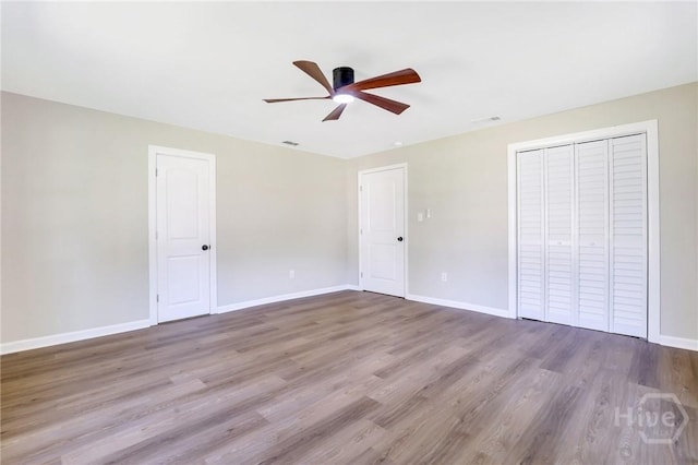 55 Saint Johns Ave, Savannah, GA 31404 - unfurnished bedroom with baseboards, wood finished floors, a ceiling fan, and a closet