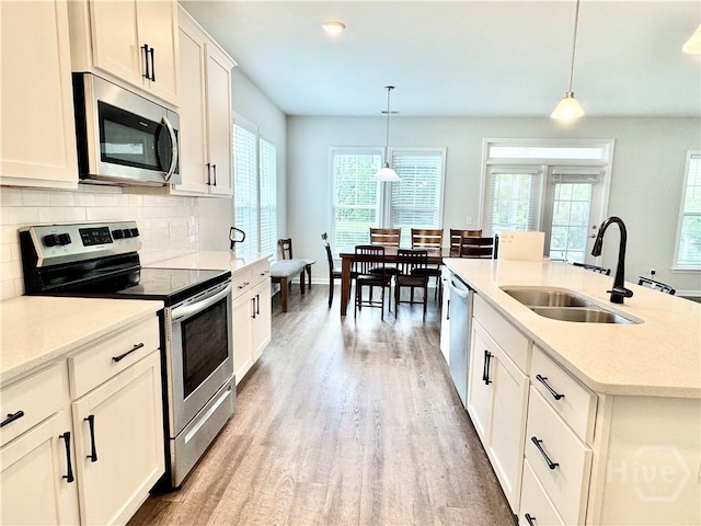 128 Melody Dr, Pooler, GA 31322 - kitchen featuring appliances with stainless steel finishes, a sink, light wood-style floors, and healthy amount of natural light