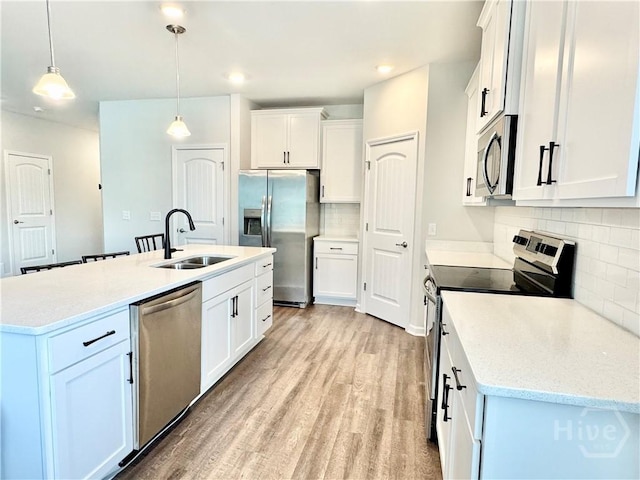 128 Melody Dr, Pooler, GA 31322 - kitchen featuring stainless steel appliances, a sink, decorative backsplash, light wood-style floors, and white cabinetry