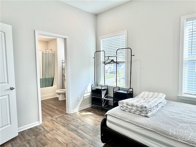 128 Melody Dr, Pooler, GA 31322 - bedroom with wood finished floors, multiple windows, baseboards, and ensuite bath