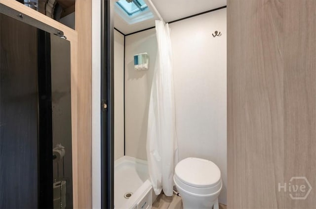 1706 E 31st St, Savannah, GA 31404 - bathroom featuring a shower stall, toilet, and a skylight