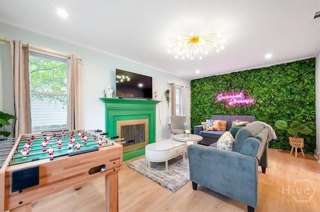 1706 E 31st St, Savannah, GA 31404 - living room featuring plenty of natural light, wood finished floors, a fireplace, a chandelier, and ornamental molding