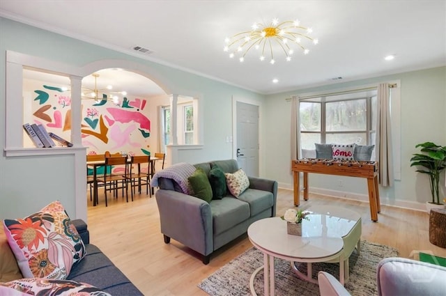 1706 E 31st St, Savannah, GA 31404 - living area with a chandelier, decorative columns, arched walkways, light wood-style flooring, and plenty of natural light