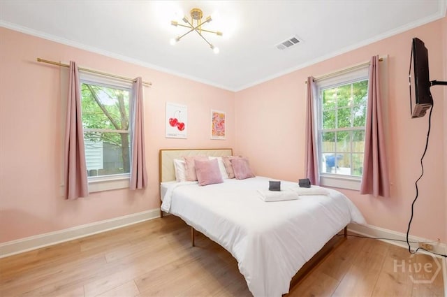 1706 E 31st St, Savannah, GA 31404 - bedroom with multiple windows, light wood-style flooring, baseboards, crown molding, and a chandelier