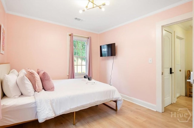 1706 E 31st St, Savannah, GA 31404 - bedroom with light wood-type flooring, ornamental molding, baseboards, and a chandelier
