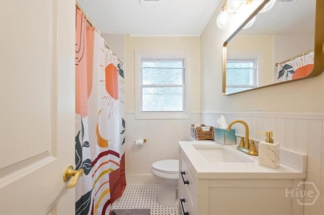 1706 E 31st St, Savannah, GA 31404 - bathroom with wainscoting, toilet, vanity, tile patterned floors, and curtained shower