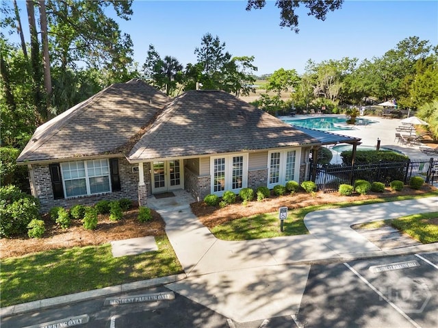 12300 Apache Ave Unit 507, Savannah, GA 31419 - view of front of house featuring french doors, brick siding, a community pool, and uncovered parking