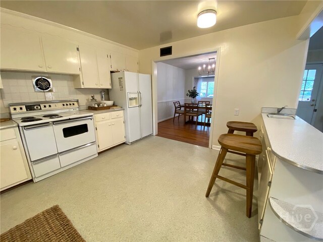 5524 Reynolds St, Savannah, GA 31405 - kitchen with white appliances, white cabinets, a sink, and healthy amount of natural light