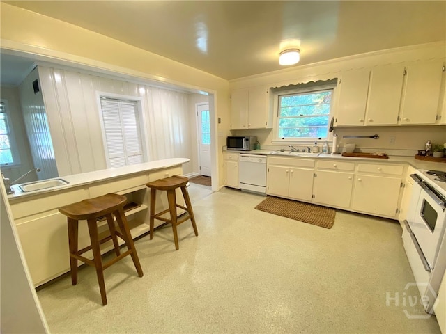 5524 Reynolds St, Savannah, GA 31405 - kitchen featuring white appliances, a sink, white cabinets, and light countertops
