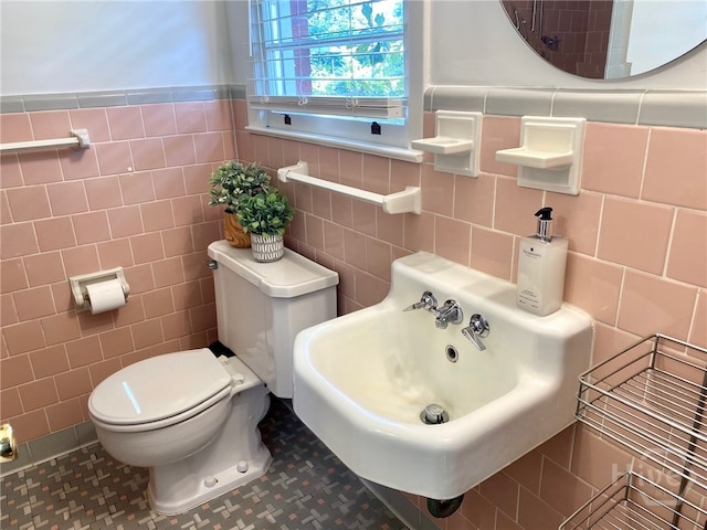 5524 Reynolds St, Savannah, GA 31405 - bathroom with tile walls, toilet, a wainscoted wall, and tile patterned flooring