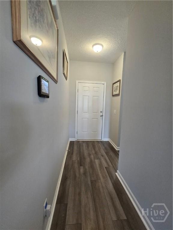 269 Brightleaf Cir, Hinesville, GA 31313 - corridor featuring dark wood-style floors, a textured ceiling, and baseboards