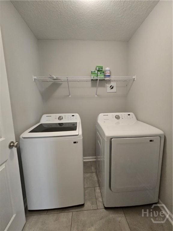 269 Brightleaf Cir, Hinesville, GA 31313 - laundry room featuring washing machine and clothes dryer, a textured ceiling, and light tile patterned floors