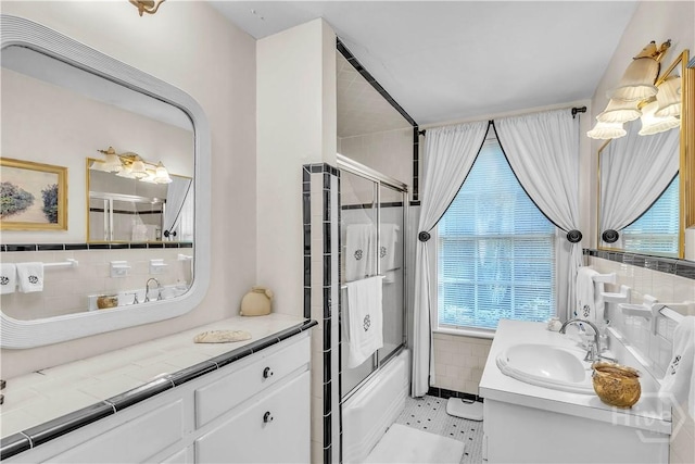 905 Goebel Ave, Savannah, GA 31404 - bathroom featuring tile walls, combined bath / shower with glass door, vanity, and decorative backsplash