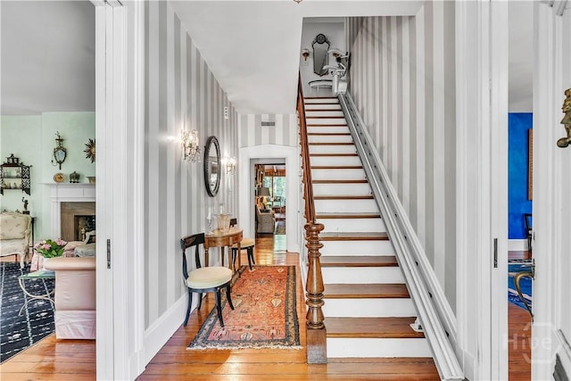 905 Goebel Ave, Savannah, GA 31404 - stairs with wallpapered walls, wood-type flooring, and a fireplace