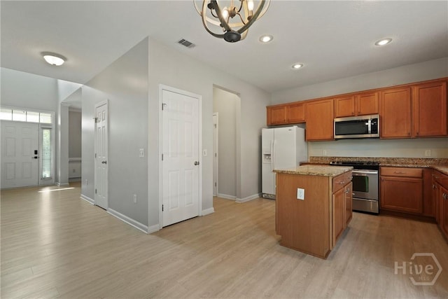 130 Willow Point Cir, Savannah, GA 31407 - kitchen with stainless steel appliances, a center island, light wood-style floors, brown cabinetry, and baseboards