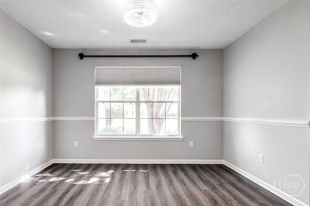 131 Warner Dr, Guyton, GA 31312 - unfurnished room with a textured ceiling, dark wood-style flooring, a chandelier, and baseboards