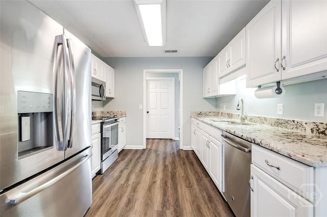 131 Warner Dr, Guyton, GA 31312 - kitchen featuring appliances with stainless steel finishes, a sink, white cabinets, and wood finished floors