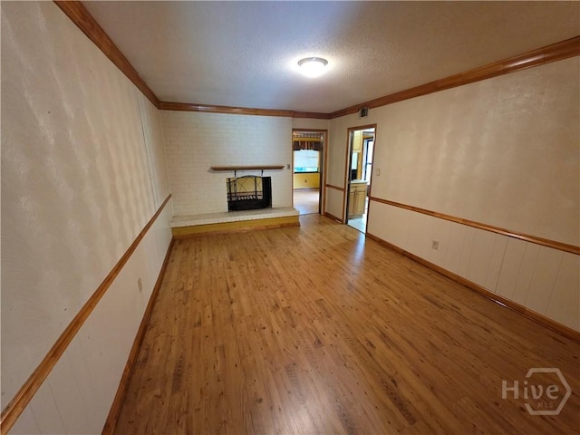 202 Leeds Gate Rd, Savannah, GA 31406 - unfurnished living room featuring a fireplace, crown molding, wood finished floors, and a textured ceiling