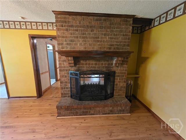 202 Leeds Gate Rd, Savannah, GA 31406 - detailed view of a textured ceiling, a brick fireplace, wood finished floors, and baseboards