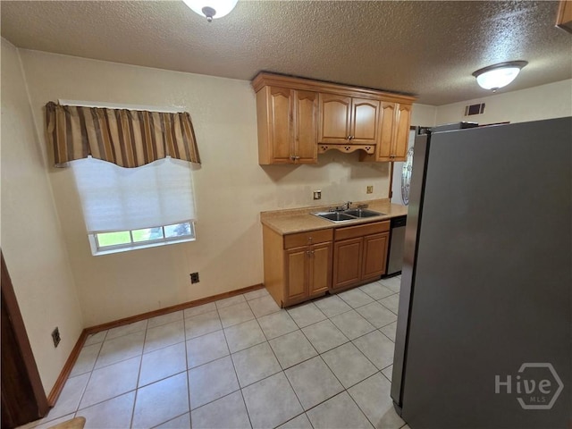 202 Leeds Gate Rd, Savannah, GA 31406 - kitchen featuring appliances with stainless steel finishes, a sink, light countertops, brown cabinetry, and a textured ceiling