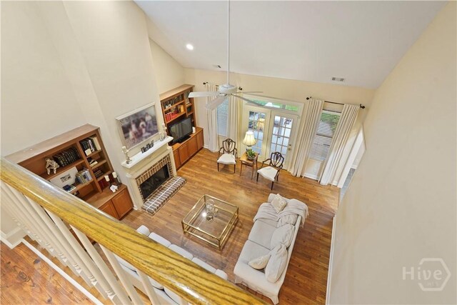 118 Woodline Dr, Savannah, GA 31410 - living room with a fireplace, a ceiling fan, wood finished floors, high vaulted ceiling, and french doors