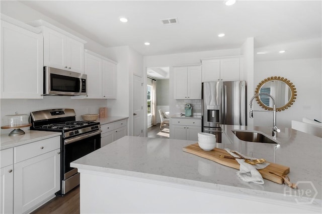797 Blue Moon Xing, Pooler, GA 31322 - kitchen featuring stainless steel appliances, a sink, decorative backsplash, light stone counters, and white cabinetry