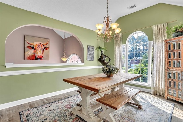 207 Pink Dogwood Ln, Pooler, GA 31322 - dining area with vaulted ceiling, baseboards, a chandelier, wood finished floors, and arched walkways
