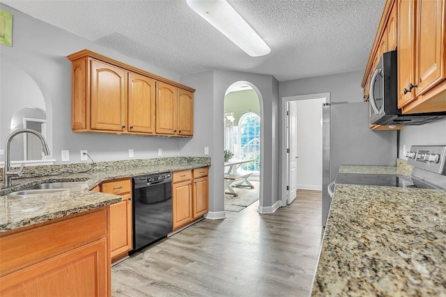 207 Pink Dogwood Ln, Pooler, GA 31322 - kitchen with black dishwasher, arched walkways, a sink, light stone counters, and light wood finished floors