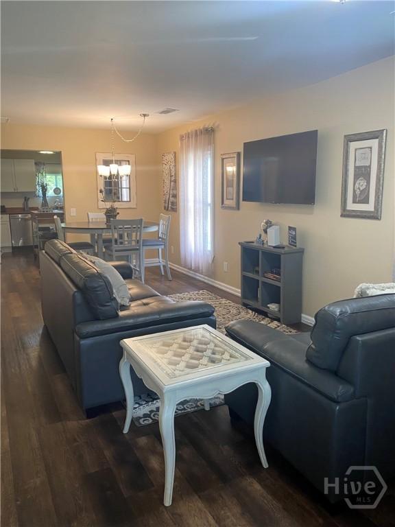 4114 Old Louisville Rd, Garden City, GA 31408 - living area featuring dark wood-style flooring, baseboards, and a chandelier