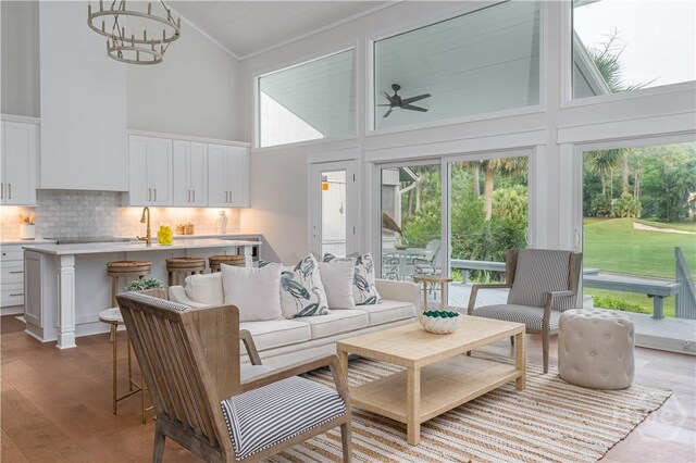 6 Schroeder Ct, Savannah, GA 31411 - living area with high vaulted ceiling, ornamental molding, wood finished floors, a chandelier, and healthy amount of natural light