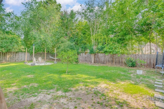 92 Shady Hill Cir, Richmond Hill, GA 31324 - view of yard with a trampoline and a fire pit