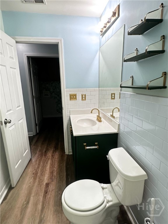 2 Timber Crest Ct, Savannah, GA 31407 - half bathroom with tile walls, wood finished floors, vanity, toilet, and wainscoting