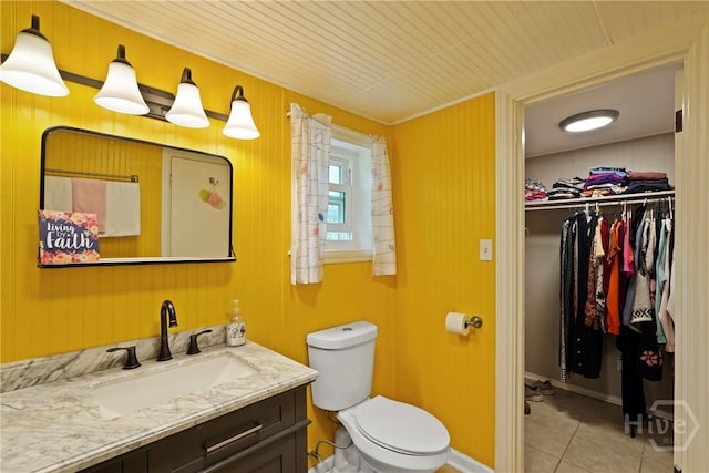 26 Arthur Cir, Savannah, GA 31406 - bathroom with vanity, tile patterned flooring, toilet, a walk in closet, and wooden walls