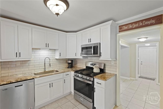 26 Arthur Cir, Savannah, GA 31406 - kitchen featuring appliances with stainless steel finishes, a sink, light tile patterned floors, white cabinetry, and light stone counters