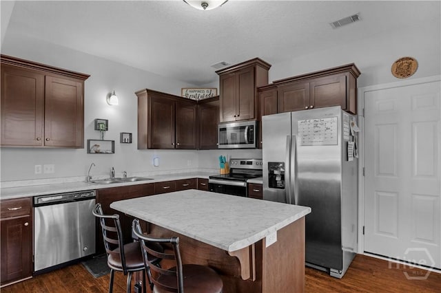 673 Burke Dr, Hinesville, GA 31313 - kitchen featuring appliances with stainless steel finishes, a sink, dark wood-style flooring, dark brown cabinetry, and light countertops