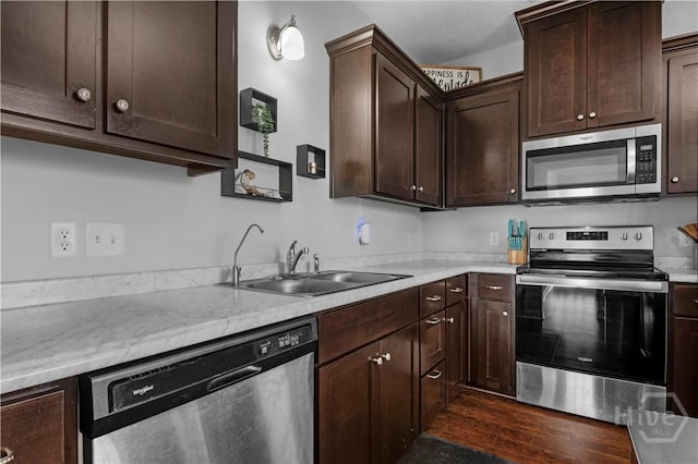673 Burke Dr, Hinesville, GA 31313 - kitchen with appliances with stainless steel finishes, a sink, dark brown cabinetry, dark wood-style flooring, and light countertops