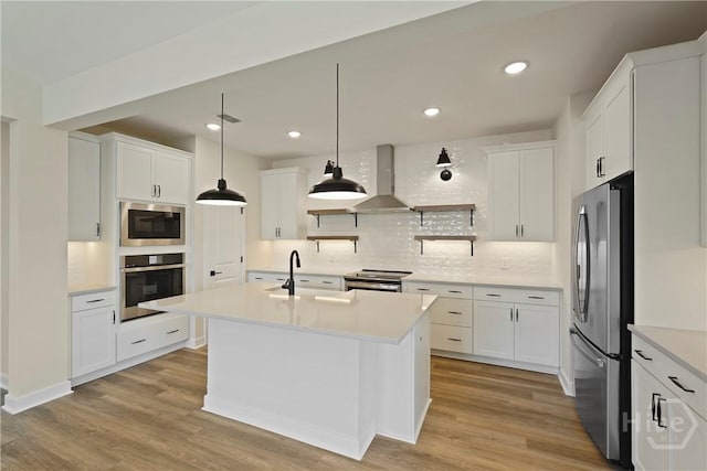 112 Mage St, Savannah, GA 31302 - kitchen featuring appliances with stainless steel finishes, wall chimney range hood, backsplash, a sink, and light wood-type flooring
