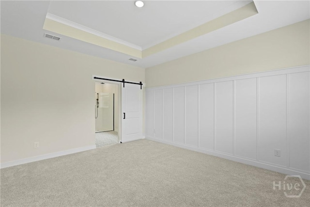 112 Mage St, Savannah, GA 31302 - spare room featuring carpet flooring, a raised ceiling, a barn door, baseboards, and ornamental molding