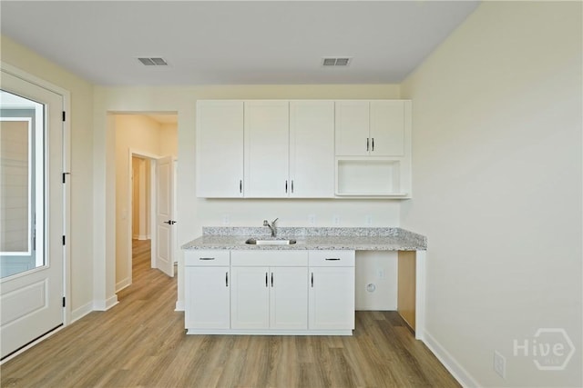 112 Mage St, Savannah, GA 31302 - kitchen featuring a sink, light wood-style flooring, white cabinets, and baseboards