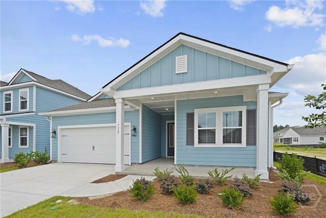 112 Mage St, Savannah, GA 31302 - view of front facade with board and batten siding, an attached garage, concrete driveway, and a porch
