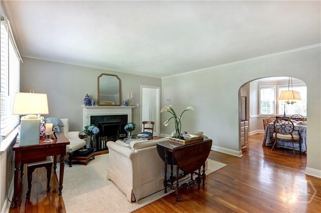 423 E 57th St, Savannah, GA 31405 - living area featuring arched walkways, wood finished floors, a high end fireplace, ornamental molding, and baseboards