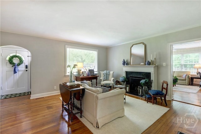 423 E 57th St, Savannah, GA 31405 - living room with hardwood / wood-style floors, crown molding, a fireplace, baseboards, and arched walkways