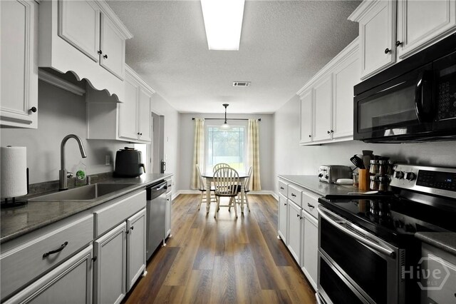 541 Deloach Rd NE, Ludowici, GA 31316 - kitchen with appliances with stainless steel finishes, a sink, dark wood-style flooring, white cabinetry, and a textured ceiling