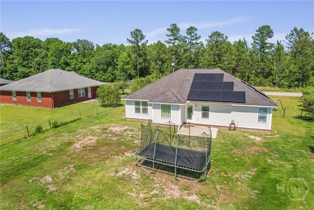 541 Deloach Rd NE, Ludowici, GA 31316 - back of property with solar panels, a trampoline, and a wooded view