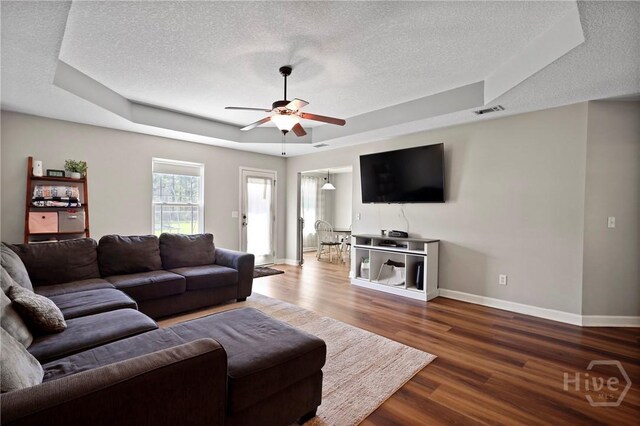 541 Deloach Rd NE, Ludowici, GA 31316 - living area featuring a raised ceiling, a textured ceiling, baseboards, ceiling fan, and wood finished floors