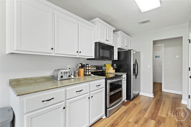 541 Deloach Rd NE, Ludowici, GA 31316 - kitchen featuring stainless steel appliances, white cabinetry, light wood-style floors, light countertops, and baseboards